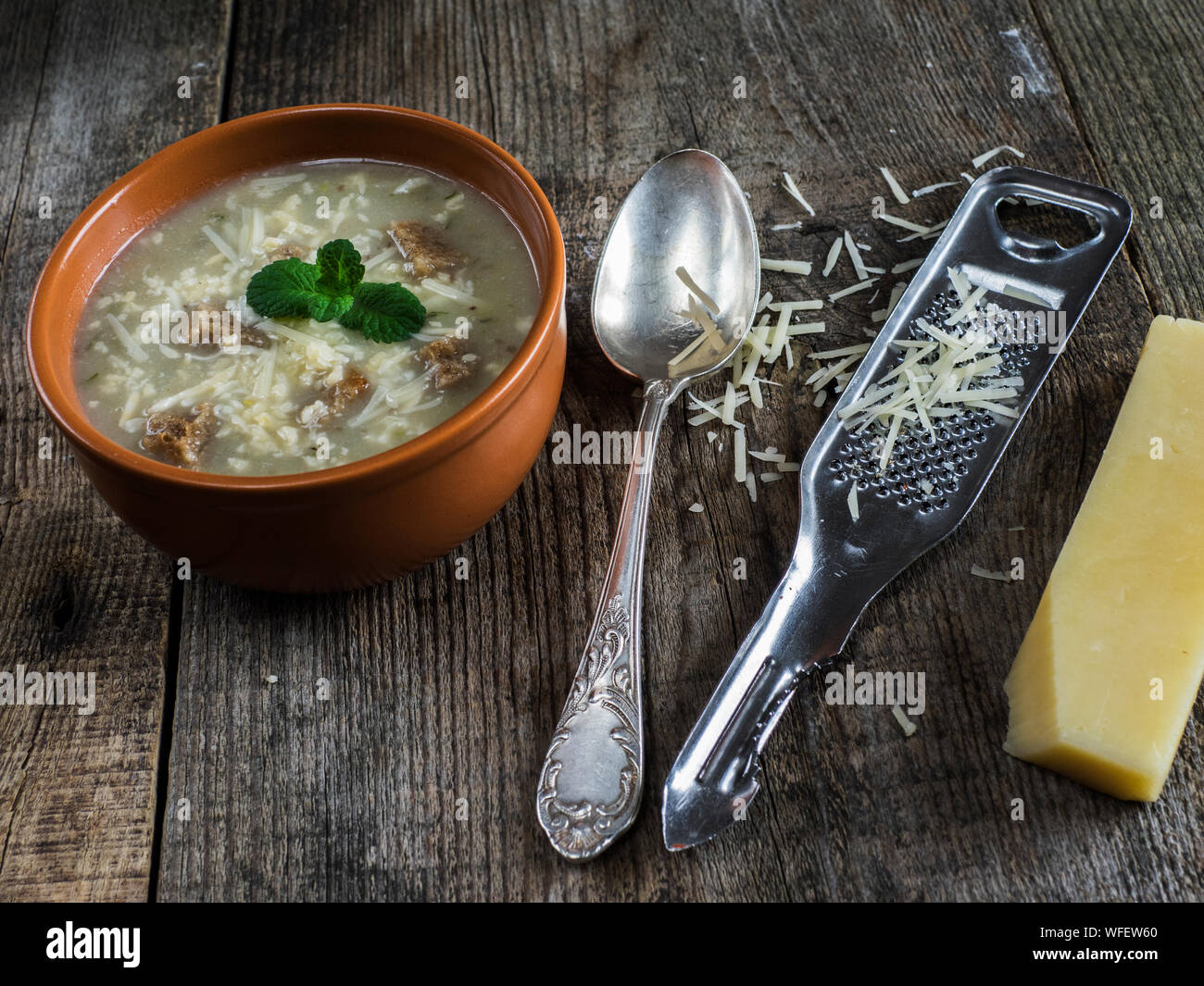Close-up Of Vegetable Soup With Croutons And Grated Cheese On Wooden Table Stock Photo