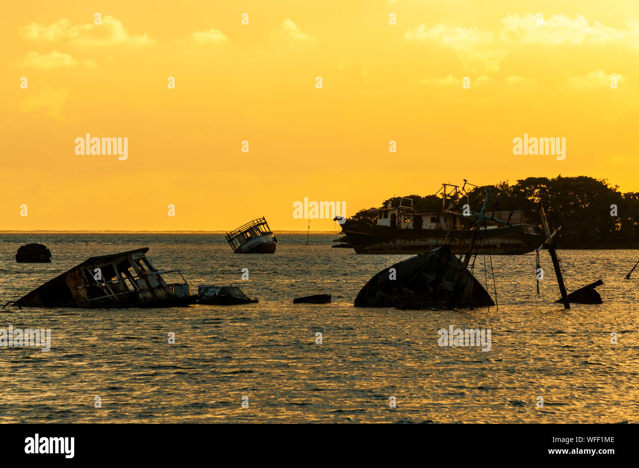 Shipwrecks In Sea Against Sky During Sunset Stock Photo
