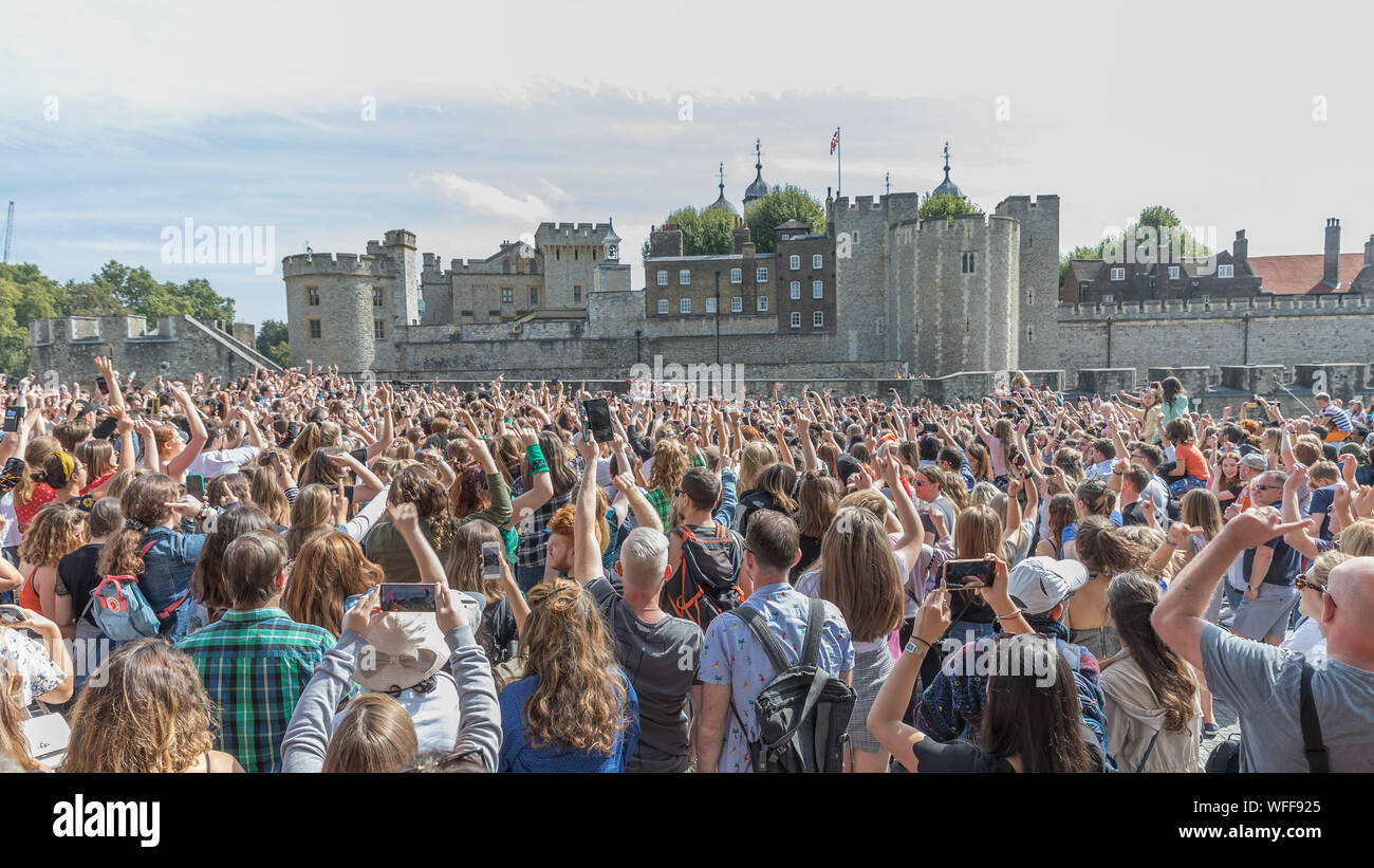 London, UK. 31st Aug, 2019. Queens from SiX the Musical and their Queendom of fans participate in a Flashmob at the Tower of London. Stars adn fans of The smash-hit musical about the six wives of Henry VIII, with music and lyrics by Toby Marlow and Lucy Moss and choreography by Carrie-Anne Ingrouille assembled in front of the Tower of London to perform a choreographed dance to the shows finale song 'One of a Kind' Credit: amanda rose/Alamy Live News Stock Photo