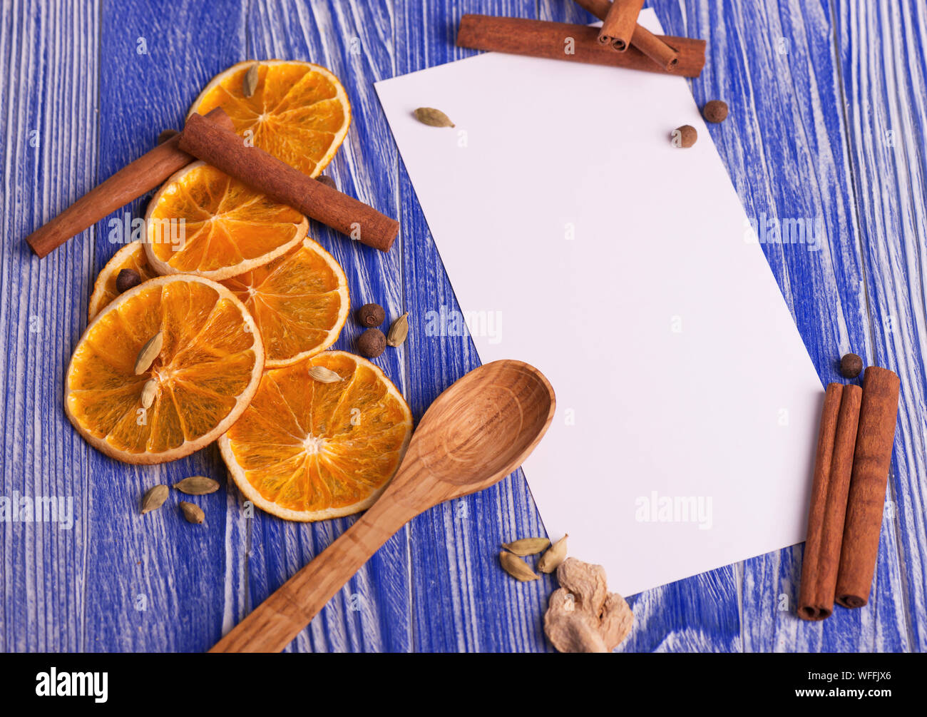 Christmas decoration. Blank for recipes with dried orange slices, cinnamon and spices on a wooden blue background. Stock Photo
