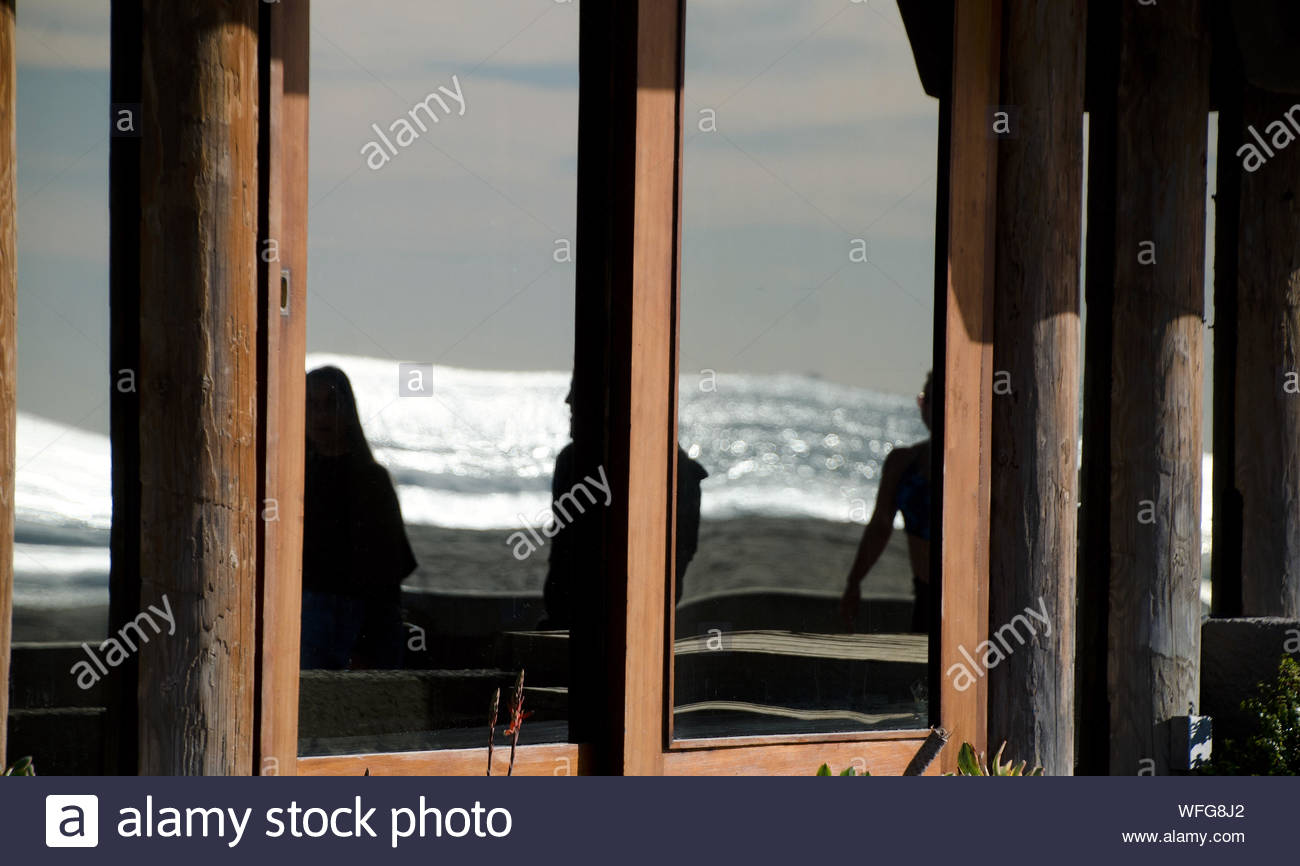 Framed Reflections In Glass And Log Walls Of A Building Next