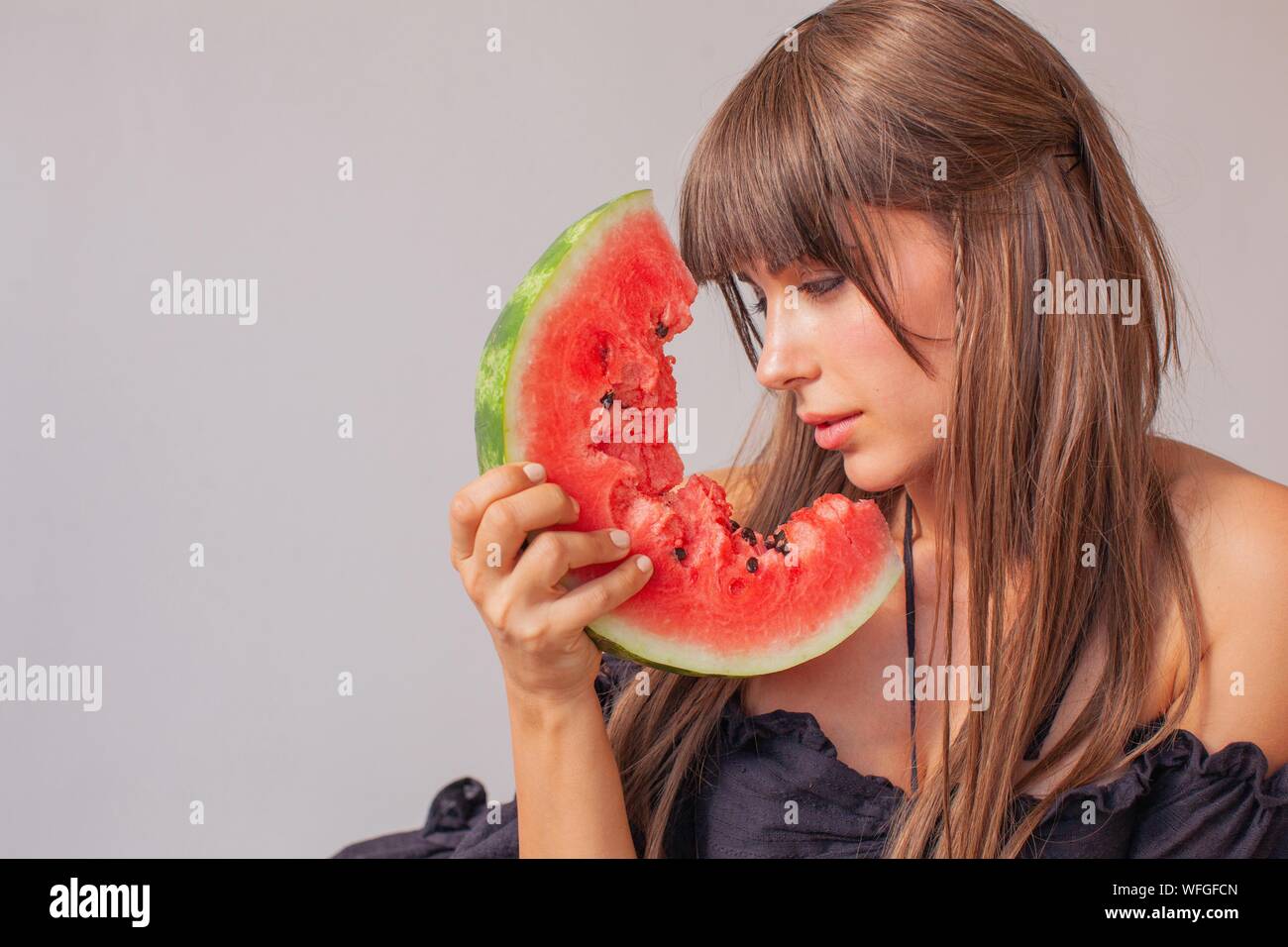 Woman looking at a slice of watermelon Stock Photo