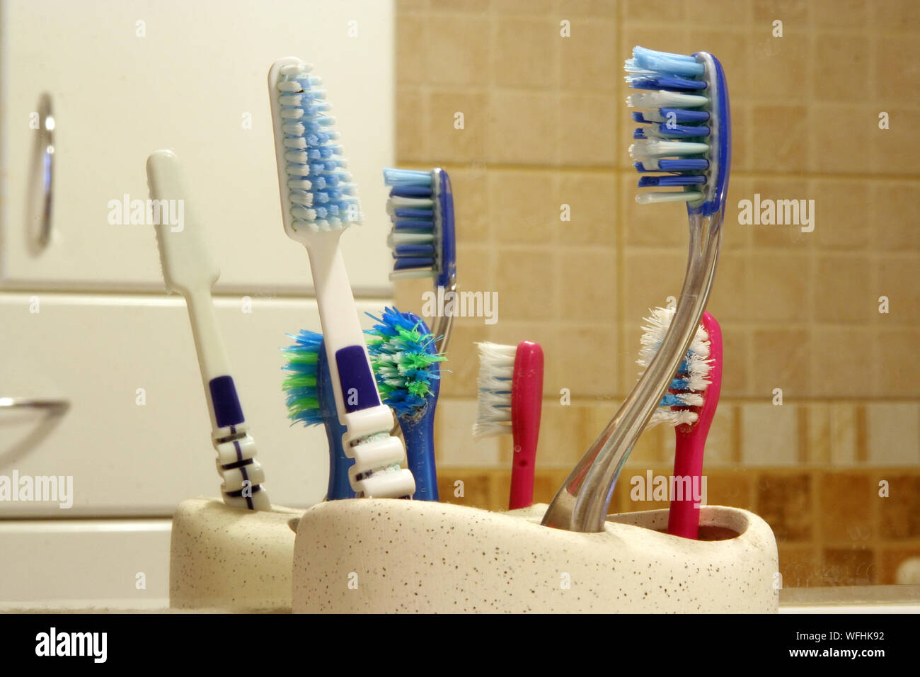 Family toothbrushes in front of mirror. Used toothbrushes. Stock Photo