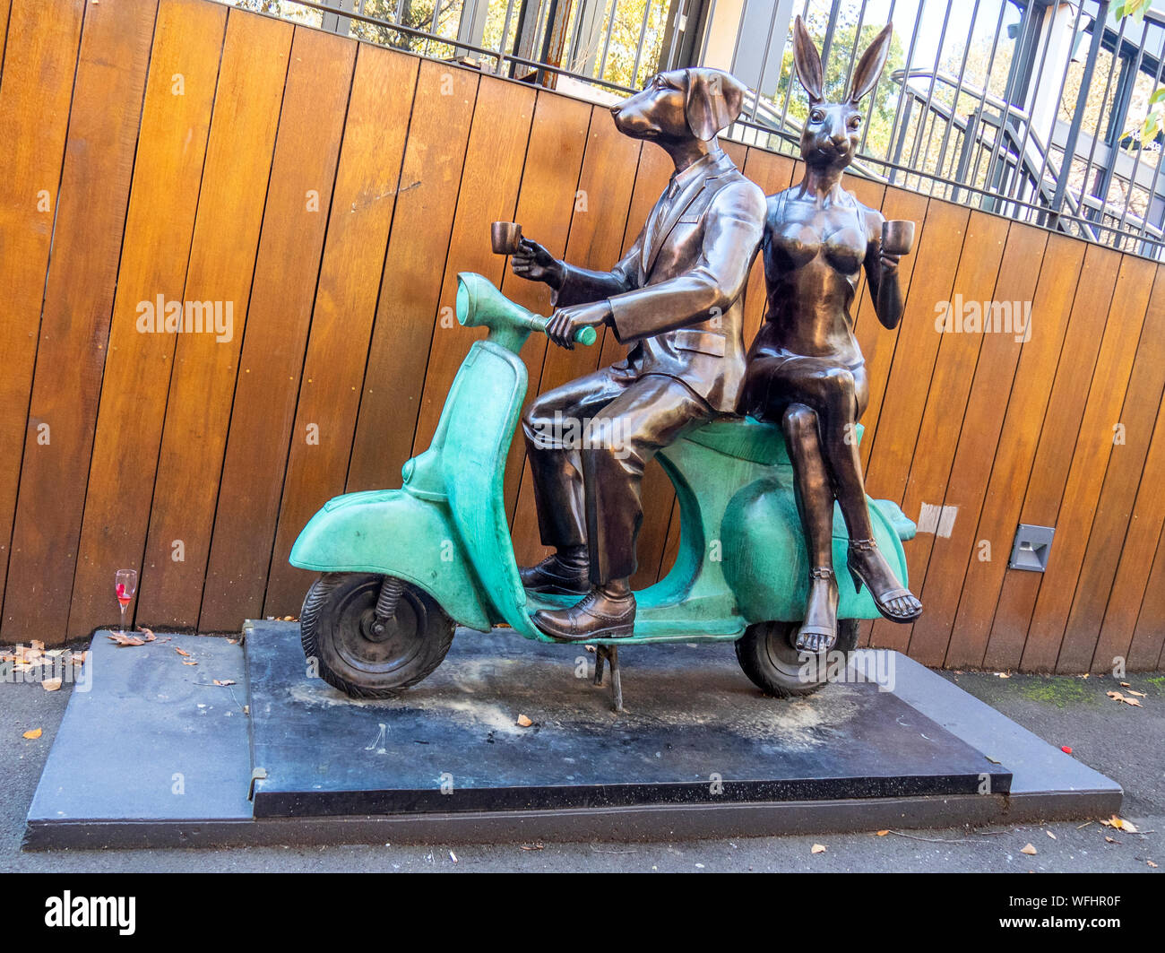 Bronze sculpture of Dogman and Rabbitwoman on a Vespa by sculptors Gillie and Marc Schattner located in Surrey Hills Sydney NSW Australia. Stock Photo