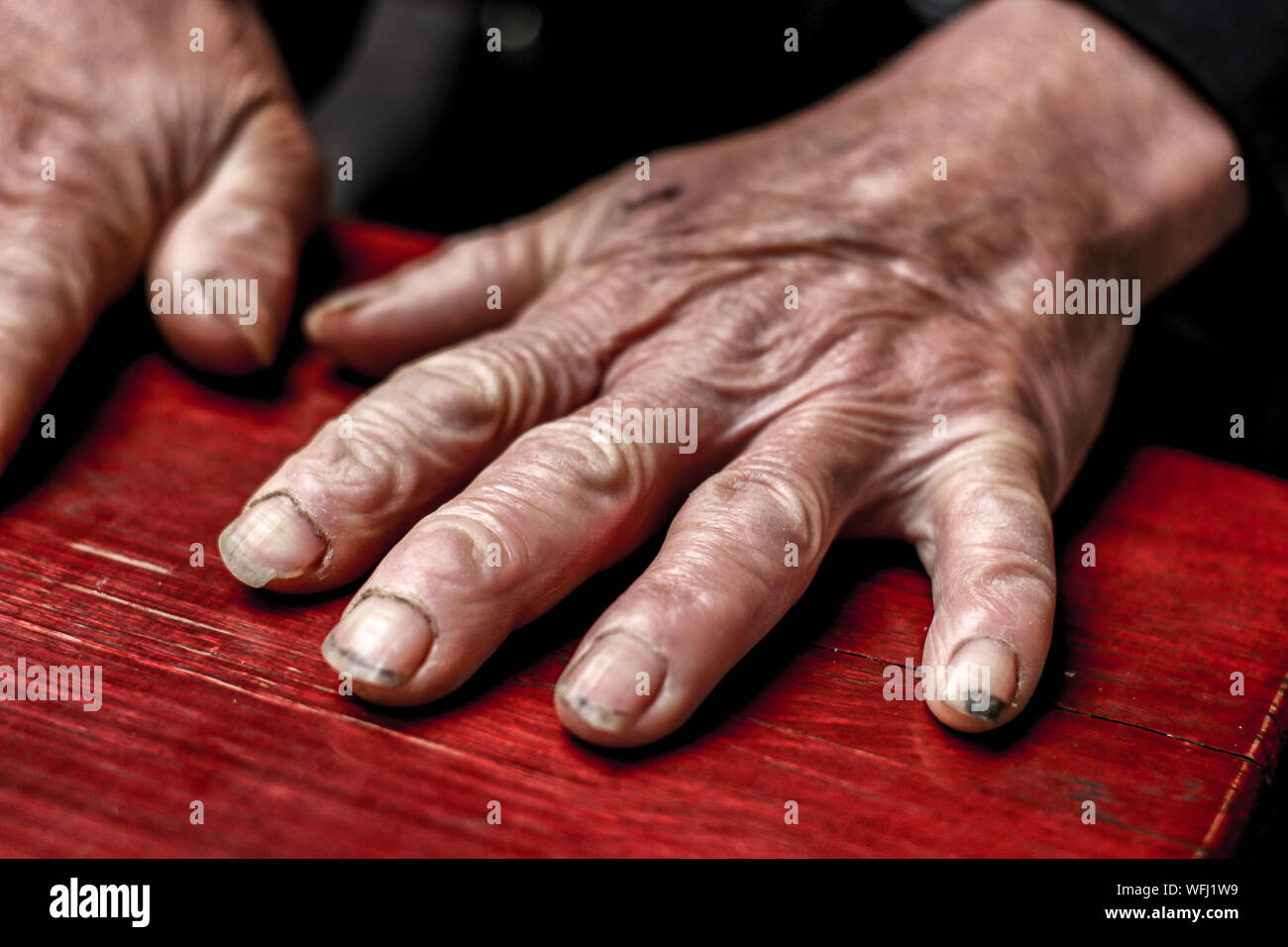 Cropped Hands Of Senior Adult On Table Stock Photo