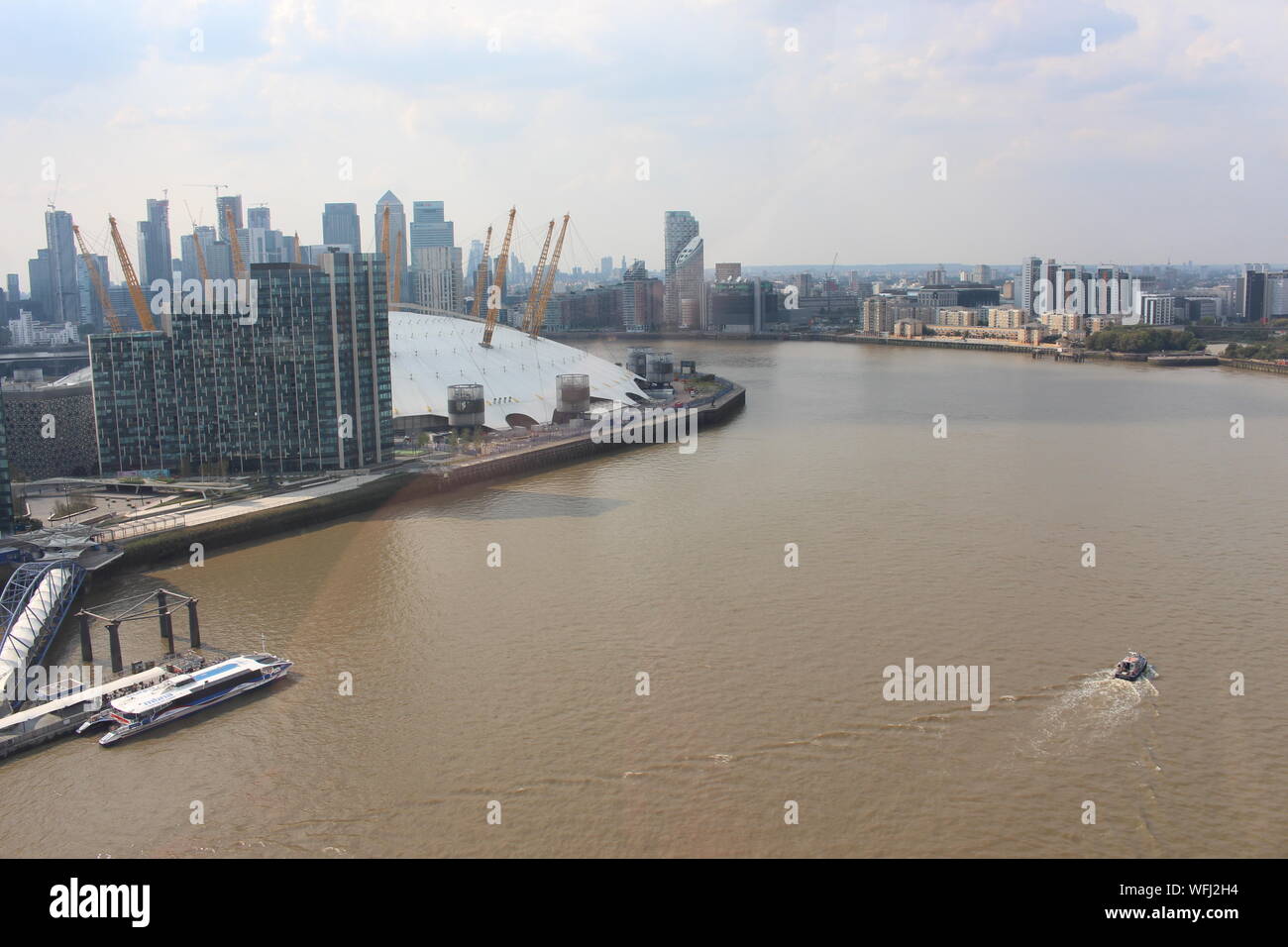 An aerial view from the Emirates cable car over the Thames, including the river Thames, the 02 Arena, Canary Wharf skyline. Stock Photo