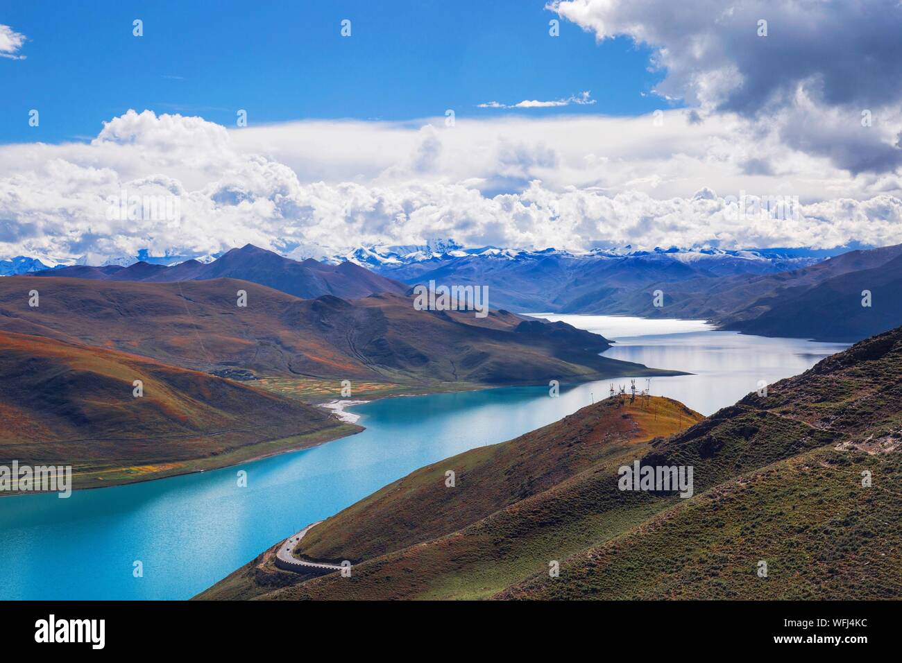 Scenic View Of Turquoise River Amidst Mountains Against Cloudy Sky Stock Photo