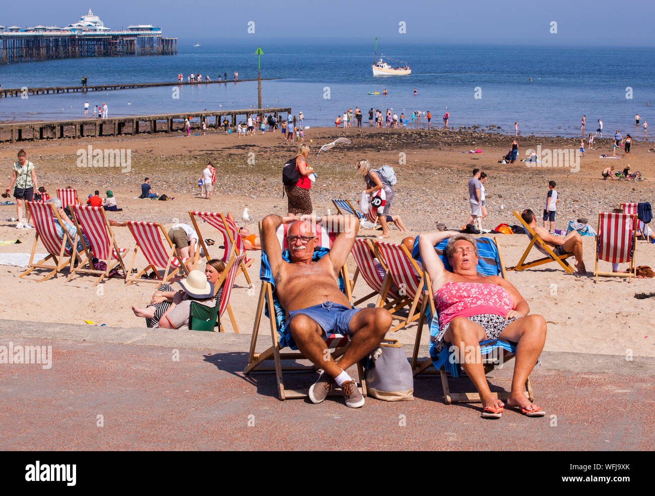 Elderly man and woman asleep in deckchairs on the promenade at the seaside resort of Llandudno North Walespeople Stock Photo