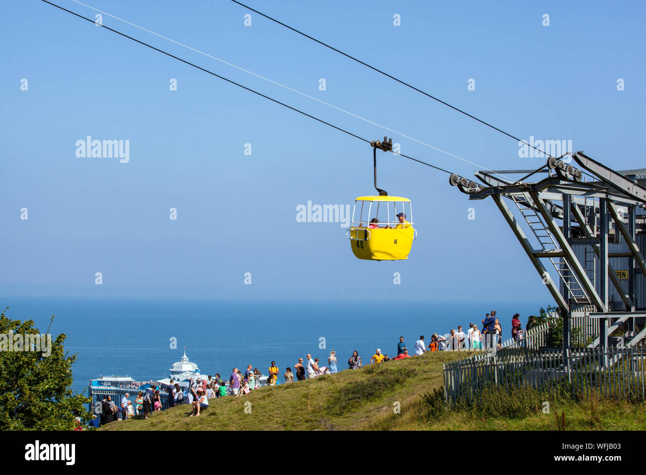 People tourists holidaymakers queuing for the cable car coming out of