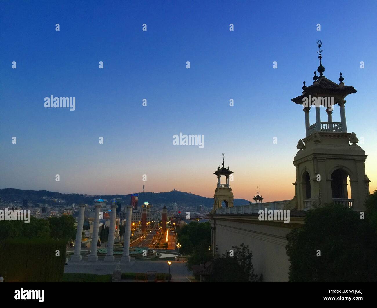 Columns By Magic Fountain Of Montjuic Against Blue Sky During Sunset Stock Photo