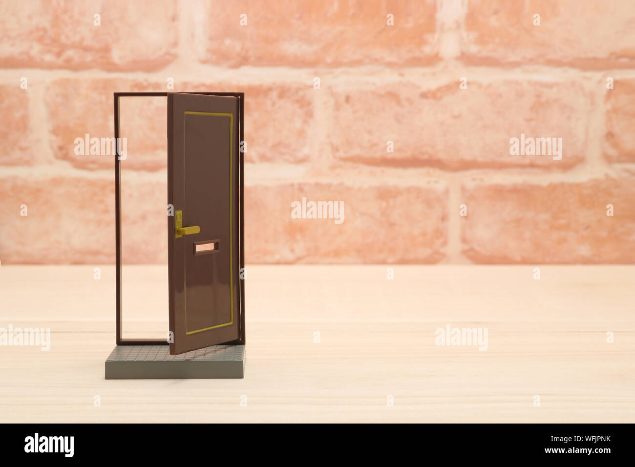 Close Up Of Small Toy Door Frame Against Brick Wall Stock Photo