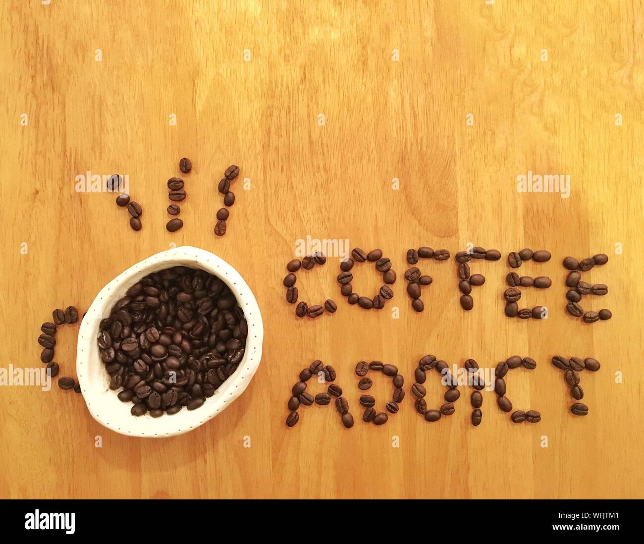 Close Up Of Coffee Addict Text Made With Roasted Beans On Table Stock Photo