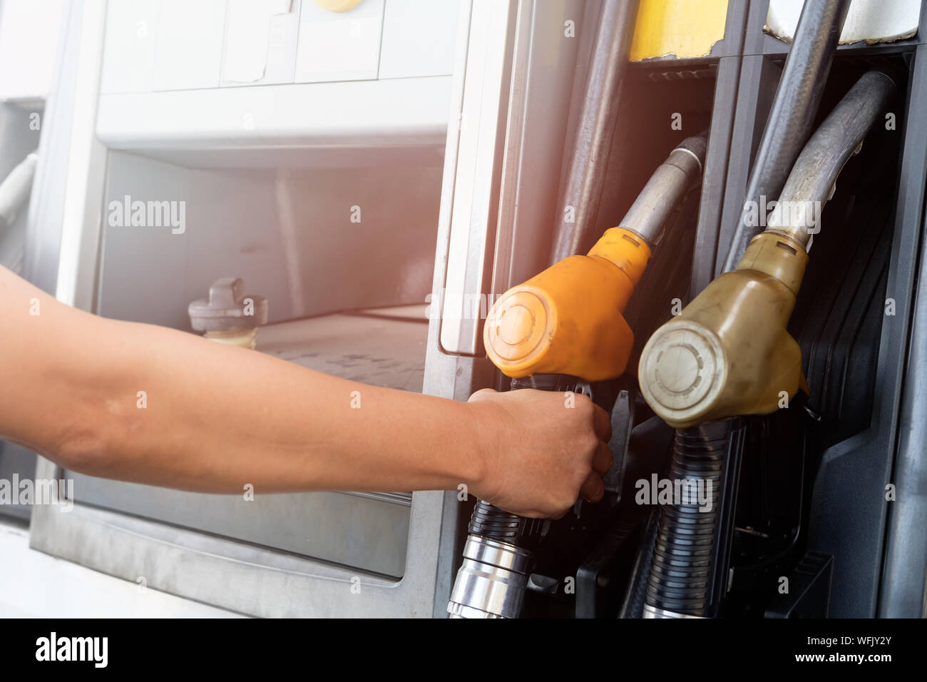 Cropped Hand Holding Fuel Pumps At Gas Station Stock Photo