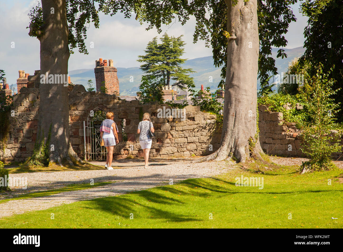 Two women walking along the castle walls in the Welsh market town of Ruthin Denbighshire Clwd North Wales Stock Photo