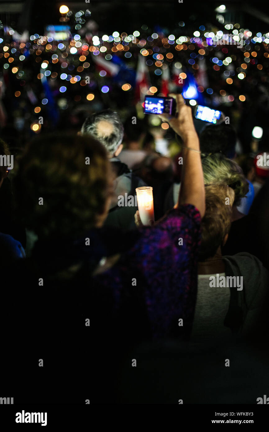 Rear View Of Female Protestor Photographing With Camera At Night Stock Photo