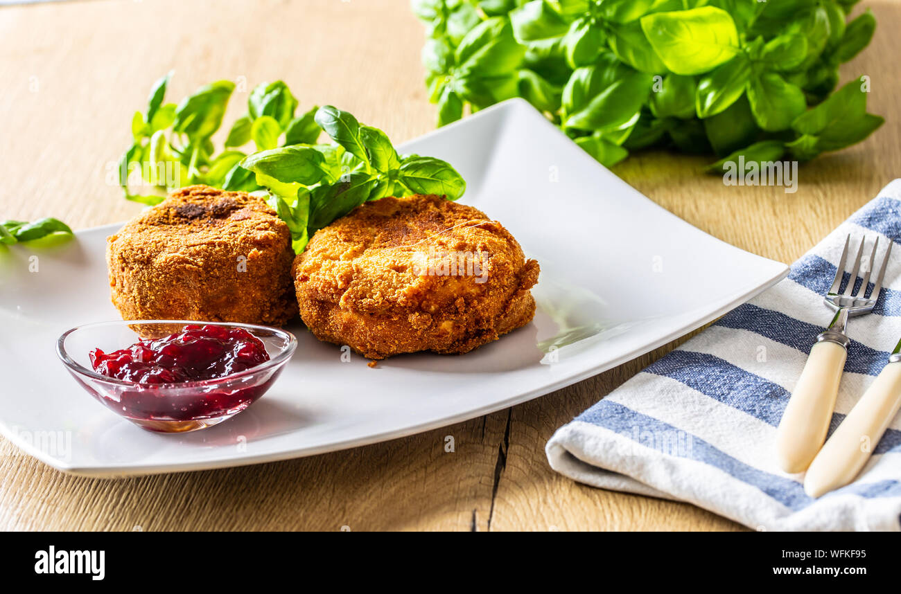 Fried camembert or brie cheese with cranberry jam and basil Stock Photo