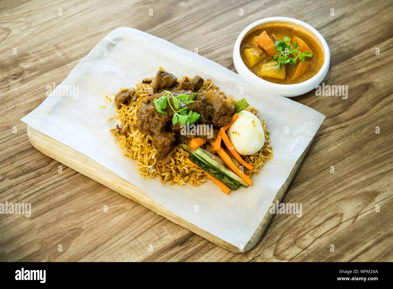 High Angle View Of Nasi Biryani With Rendang Served On Wooden Table Stock Photo