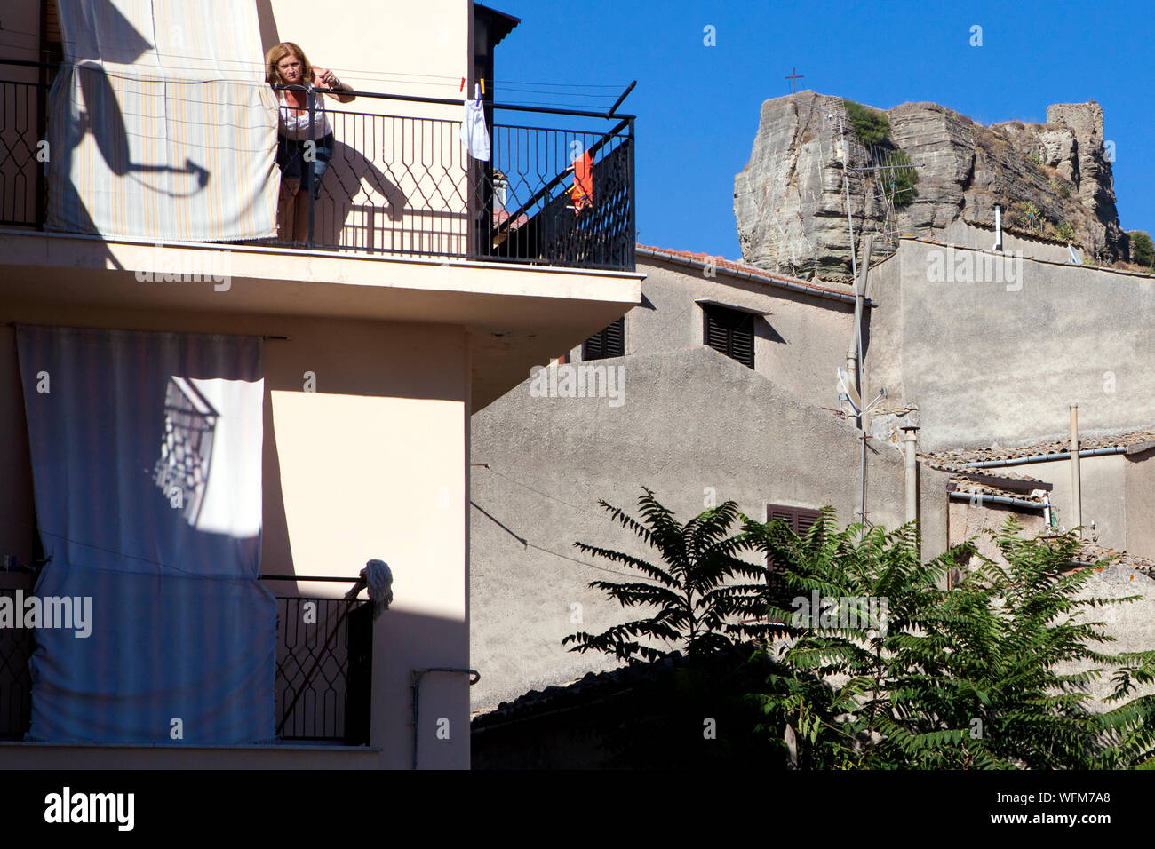 Woman on a balcony in the Sicilian village of Corleone Stock Photo