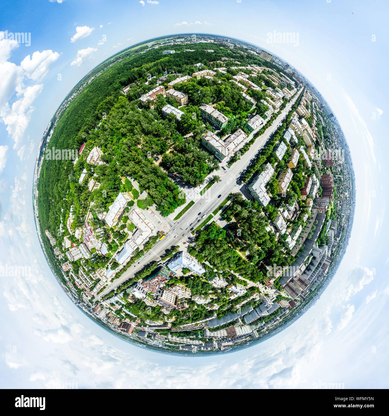 Aerial city view with crossroads and roads, houses, buildings, parks and parking lots. Sunny summer panoramic image Stock Photo