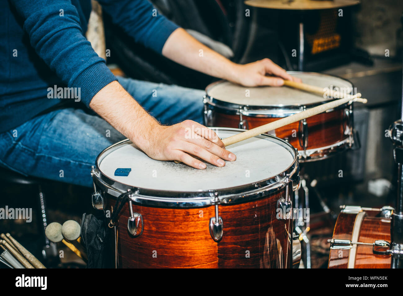 Midsection Of Man Playing Drums At Music Concert Stock Photo