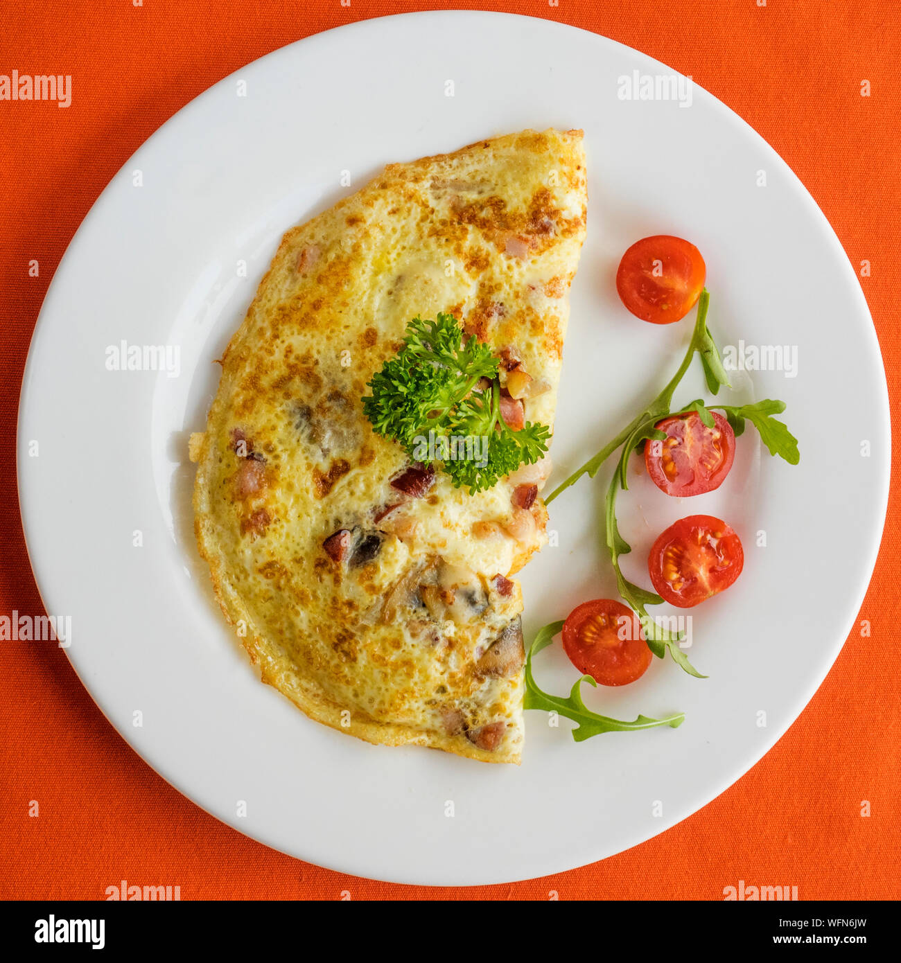 Close-up Of Omelet With Cherry Tomato Served In Plate On Table Stock Photo