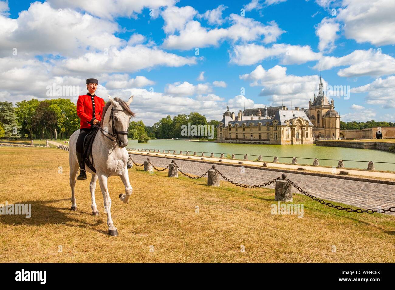 France, Oise, Chantilly, Chateau de Chantilly, the Grandes Ecuries (Great Stables), Estelle, rider of the Grandes Ecuries, runs his horse in Spanish steps in front of the castle Stock Photo