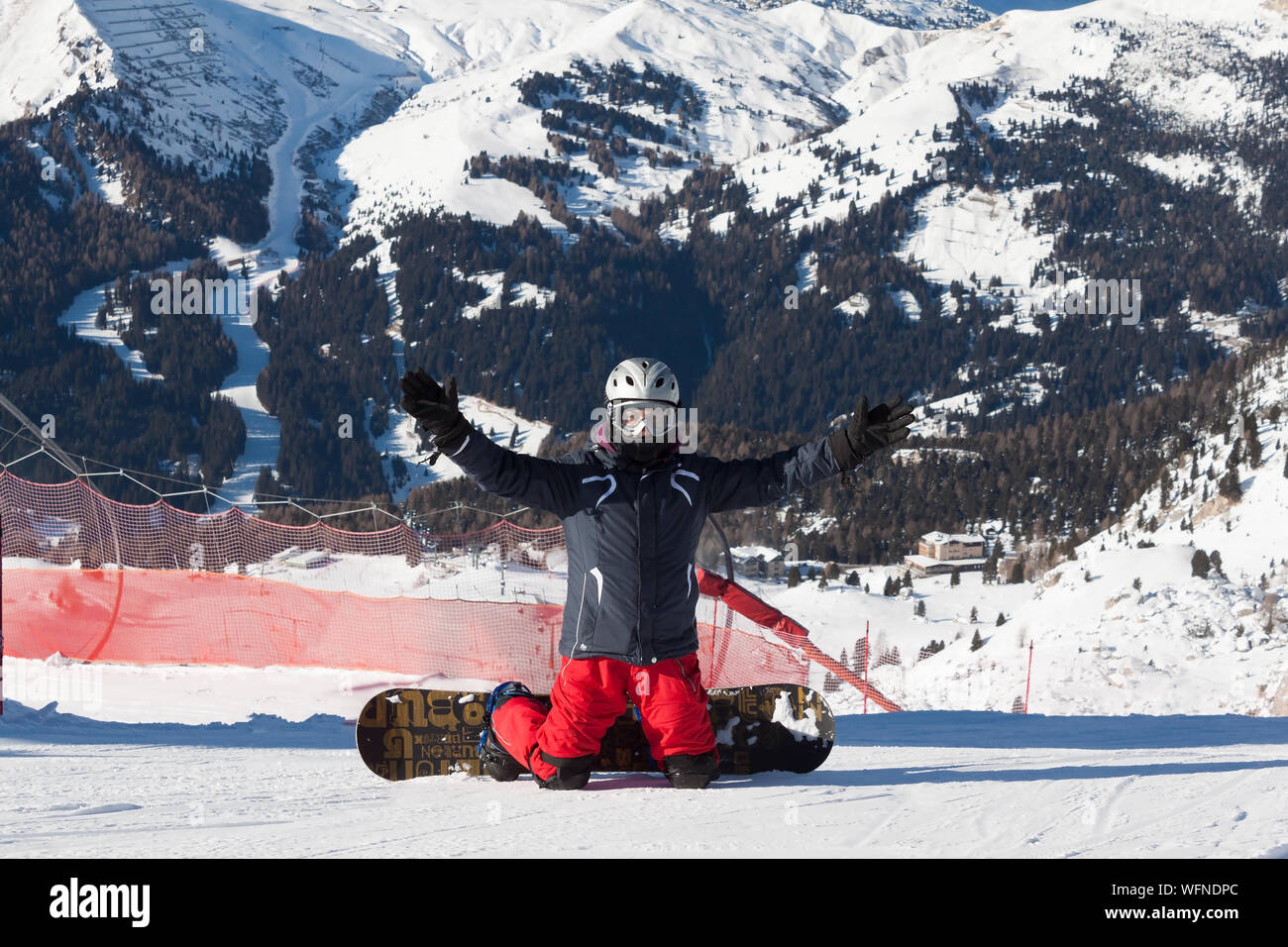 Snowboarder sitting on relax moment in Italian alps ski resort - Winter sport concept with person on top of the mountain ready to ride down Stock Photo