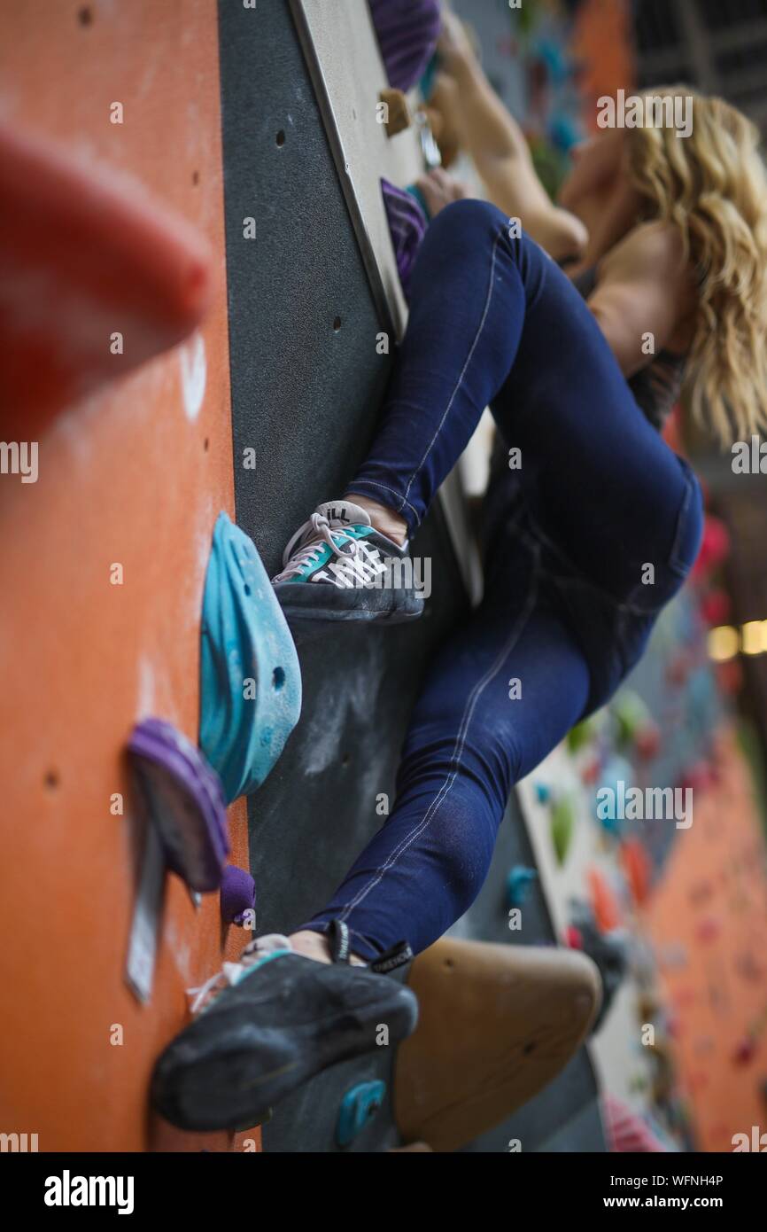 Low Angle View Of Female Athlete Climbing Wall Stock Photo