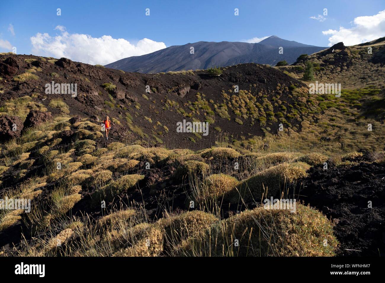 Italy, Sicily, Mount Etna Regional Nature Park, Mount Etna, UNESCO World Heritage Site, North Slope, Pads of Astragalus siculus, endemic species of Etna, woman practicing hiking Stock Photo