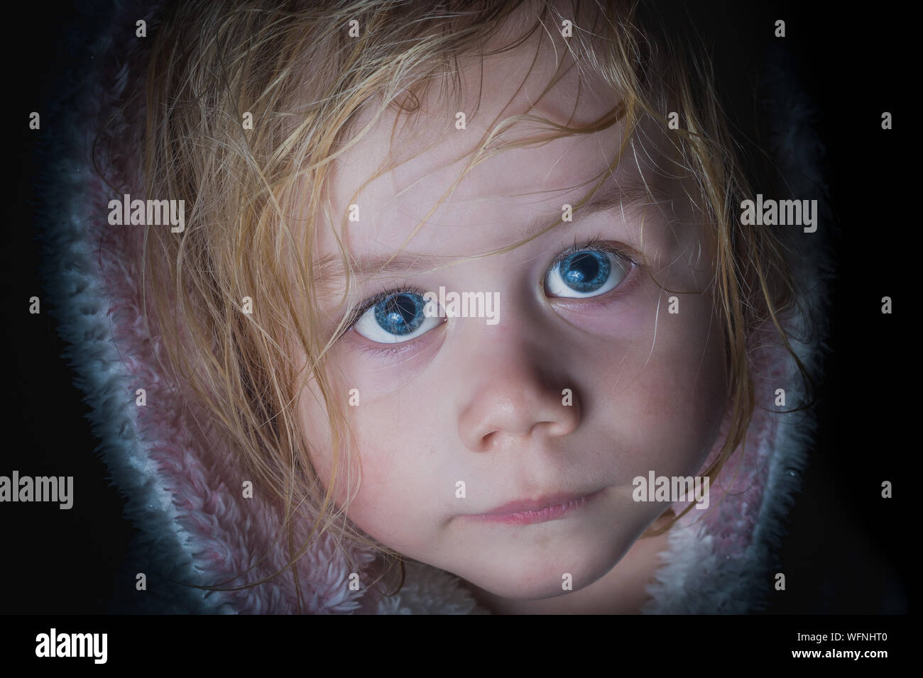 Close Up Portrait Of Cute Girl With Blue Eyes Against Black Background Stock Photo Alamy