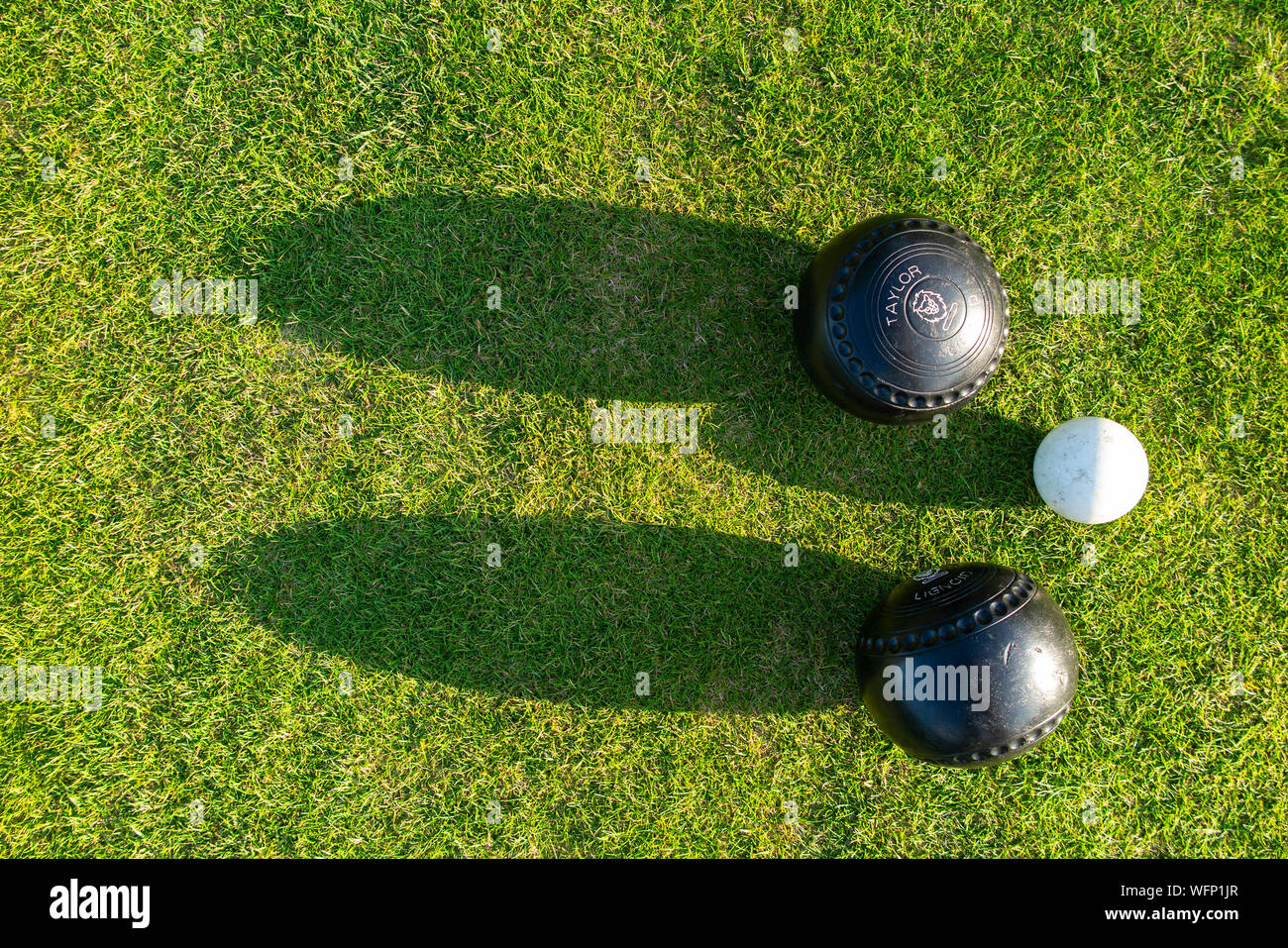 Bowling balls near the jack ball seen from above in a lawn bowls competition Stock Photo