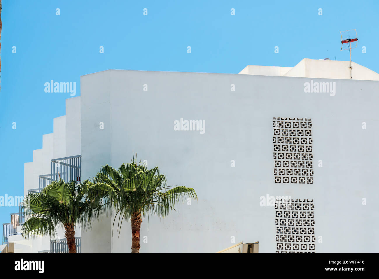 White apartment buildings on a sunny day with a blue sky. Facade of a modern apartment residential. Image is suitable for logo or poster mockups Stock Photo