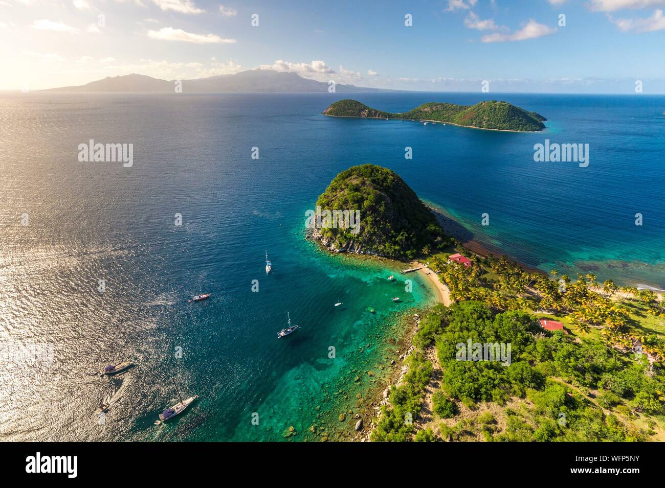 Guadeloupe, Les Saintes, Terre de Haut, the bay of the town of Terre de Haut, listed by UNESCO among the 10 most beautiful bays in the world, here the Pain de Sucre, Basse Terre in background (aerial view) Stock Photo