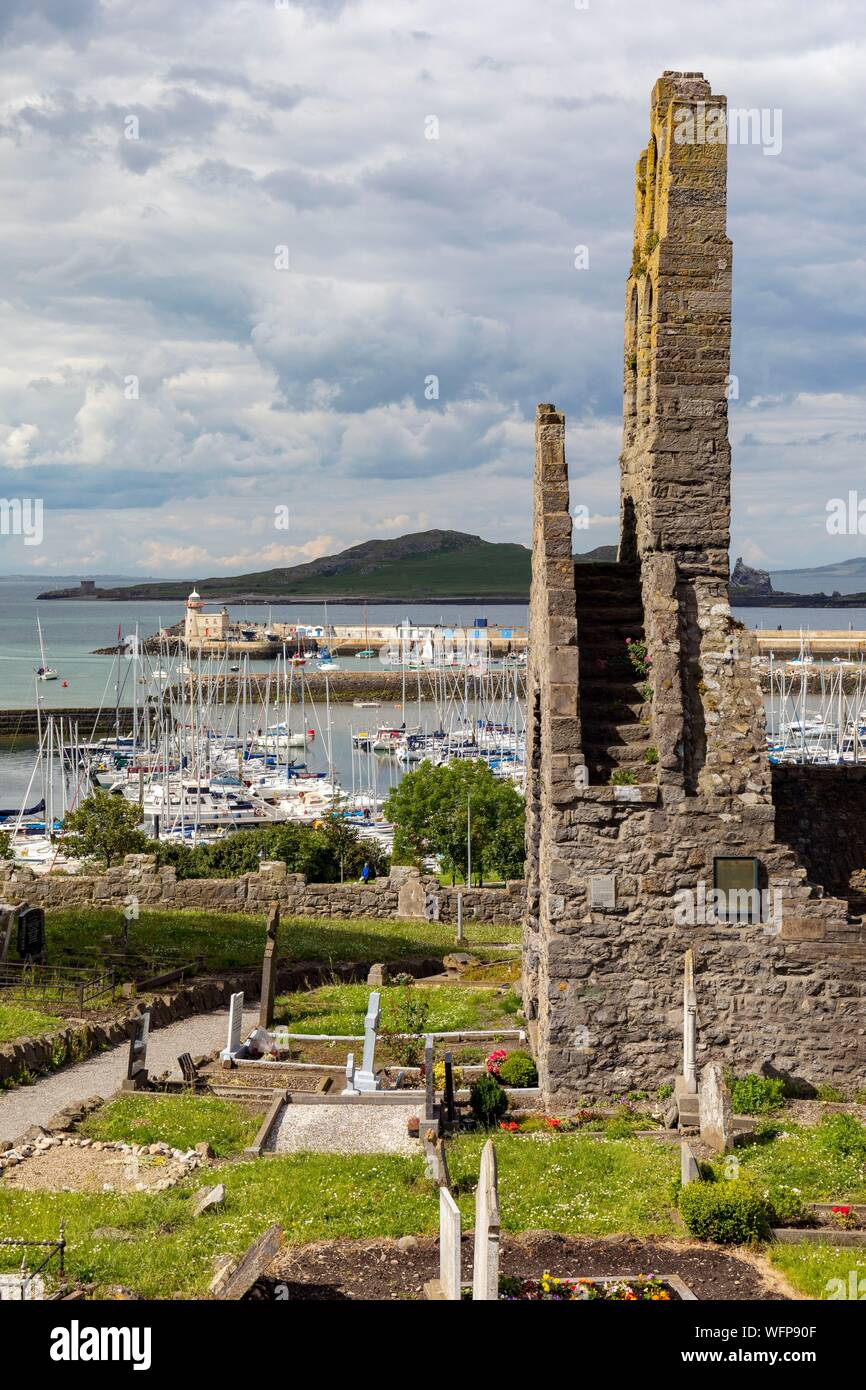 Ireland, County Fingal, Dublin's northern suburbs, Howth, former Saint Mary's church and cemetery, at the bottom the port and lighthouse of the city Stock Photo