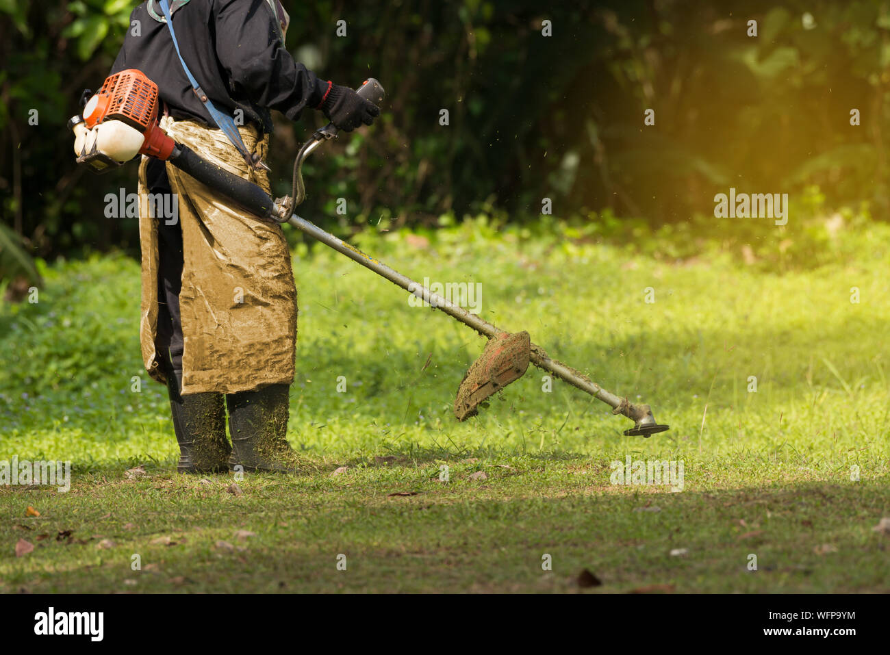 Low Section Of Man Mowing Grass Stock Photo