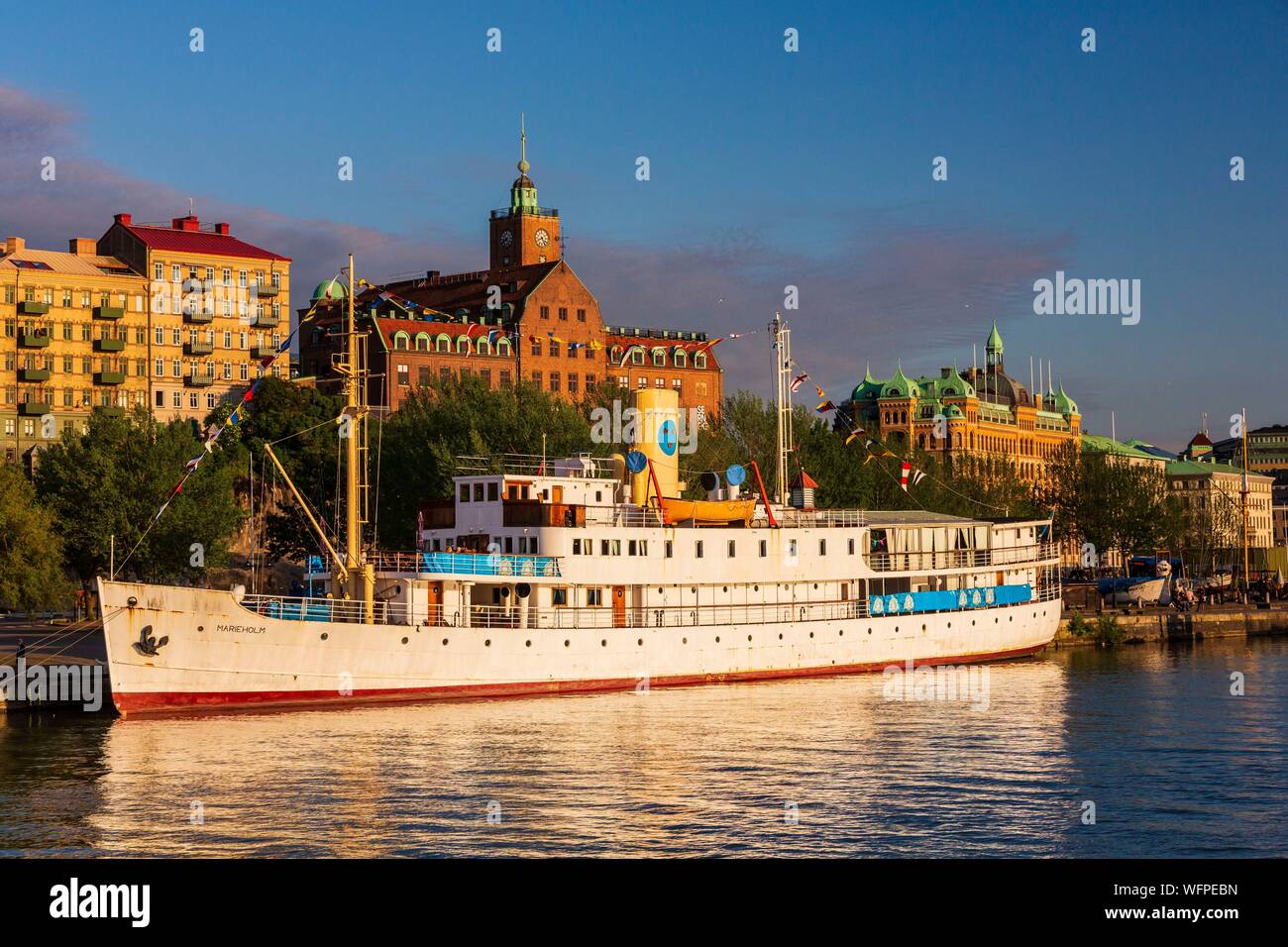 Sweden, Vastra Gotaland, Goteborg (Gothenburg), floating maritime museum, the boat restaurant Marieholm and view on Kvarnberget and its clock and the buildings of the company ASECO on Packhusplatsen Stock Photo