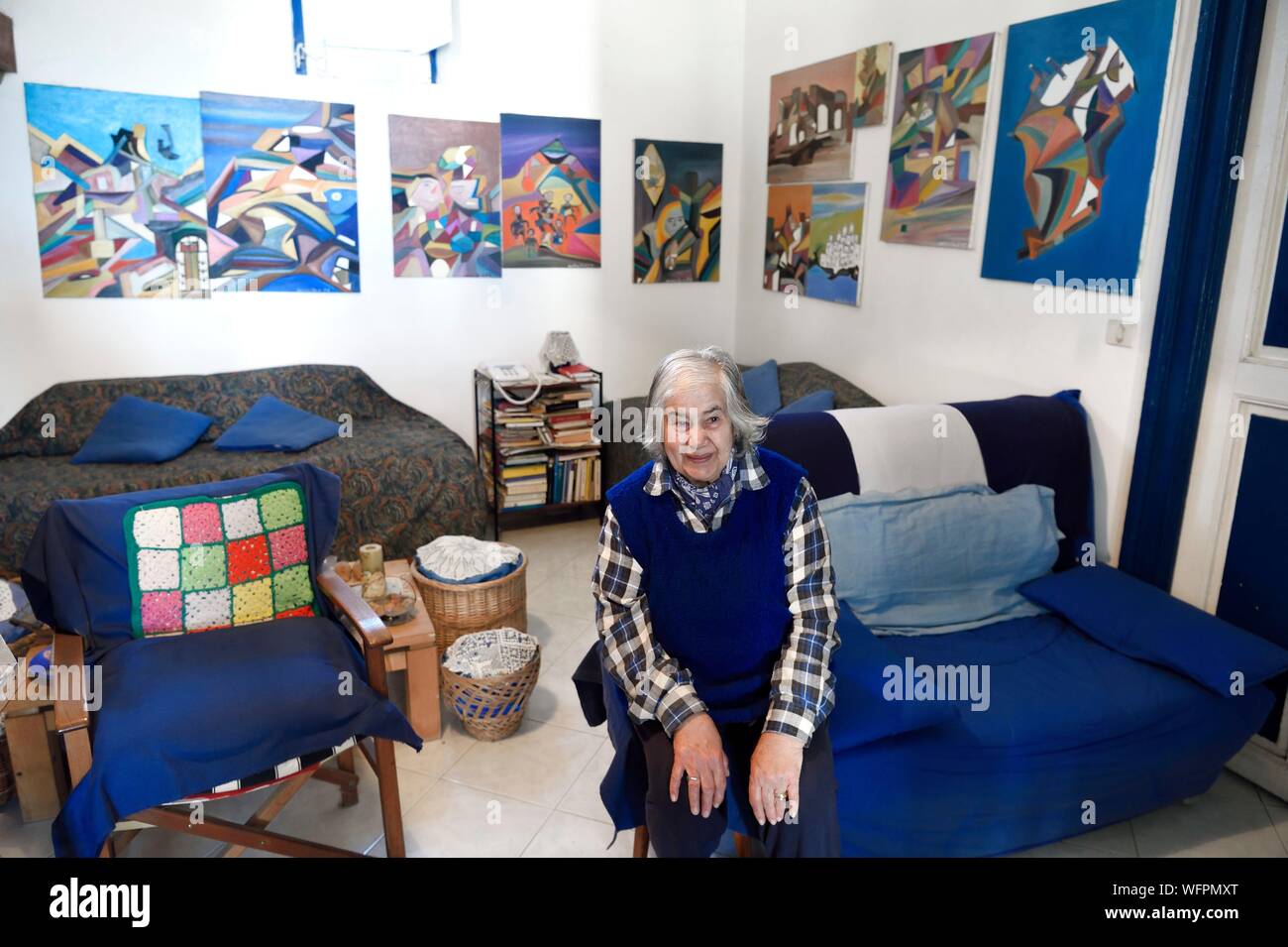 Italy, Sicily, Aeolian Islands, listed as World Heritage by UNESCO, Stromboli island, the wife of the fisherman and painter Mario Cusolito today deceased whose works can be seen in the background Stock Photo