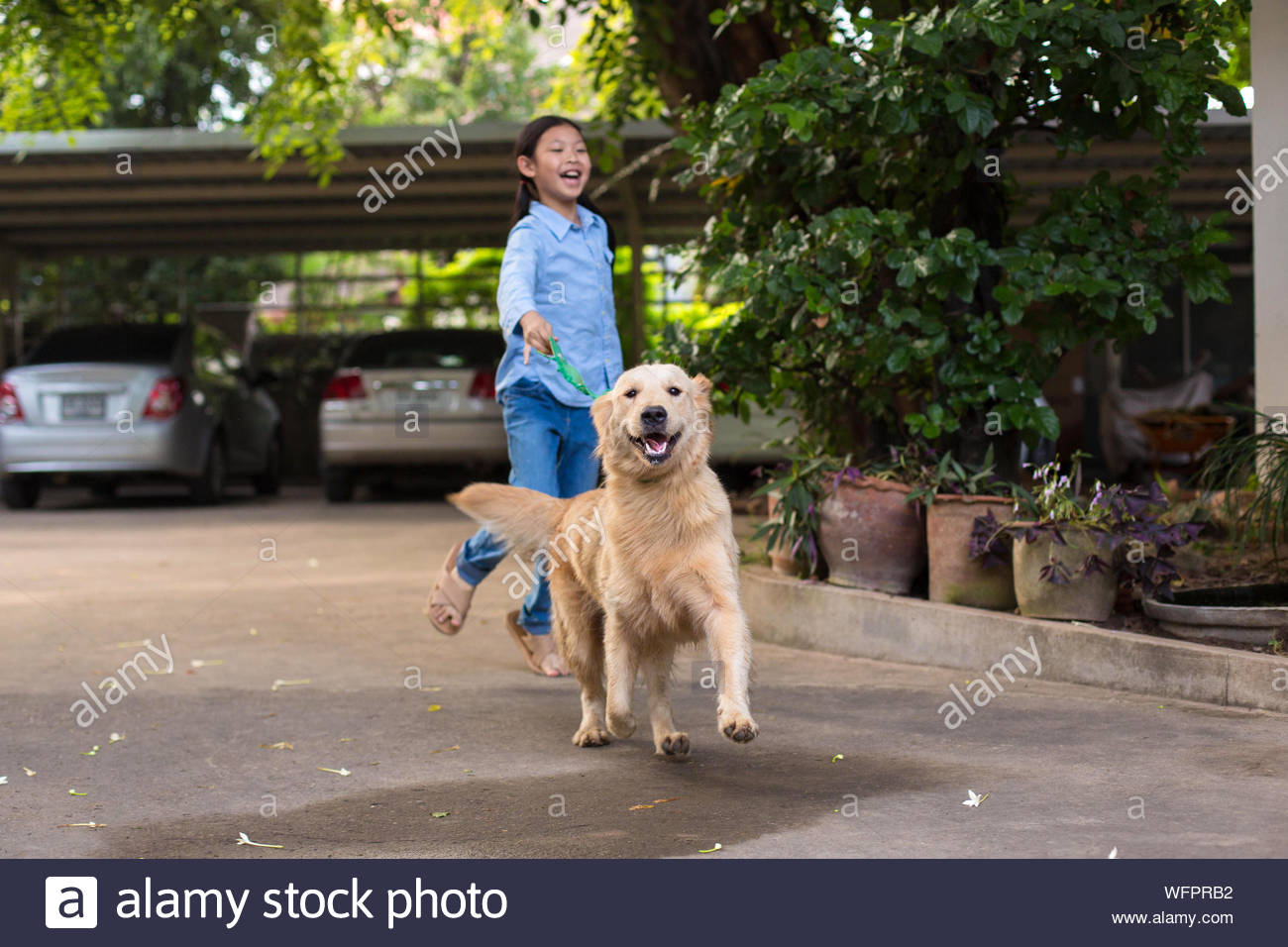 Portrait Of A Gril Running With Dog Stock Photo - Alamy