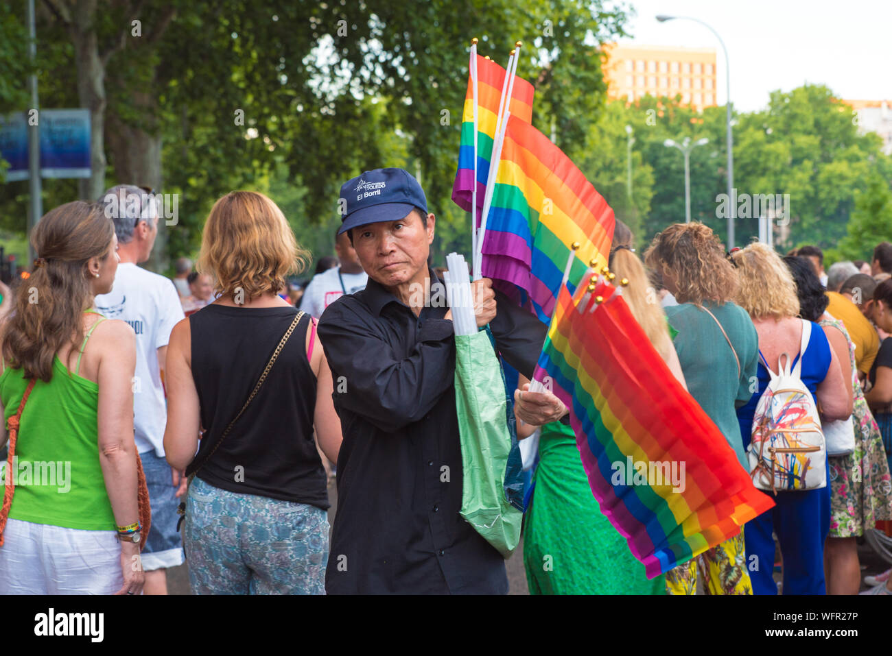 Asian man selling rainbow flags at Madrid Pride Stock Photo