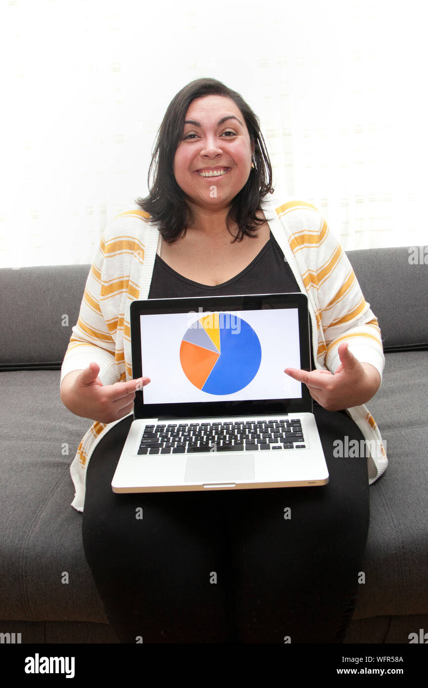 Woman working at home is happy showing off her business results or research insights from laptop Stock Photo