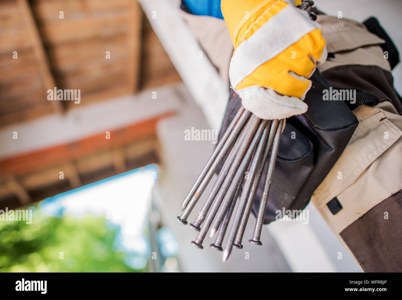 Midsection Of Person Holding Nails Stock Photo