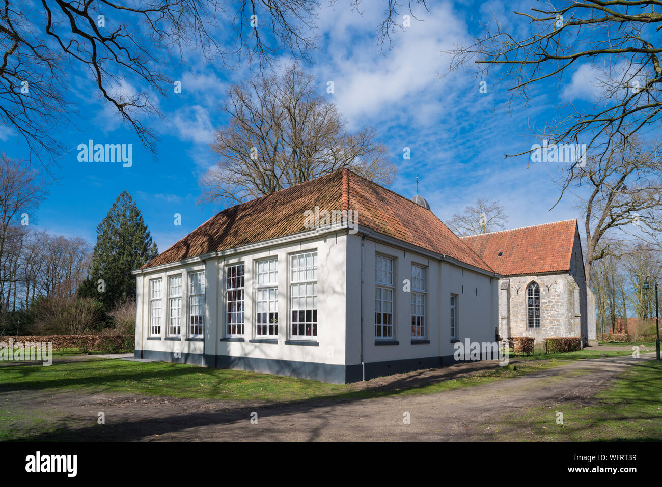 former elementary school building in 't Stift, Netherlands. Nowadays it is part of an age-old protected village scene. Stock Photo