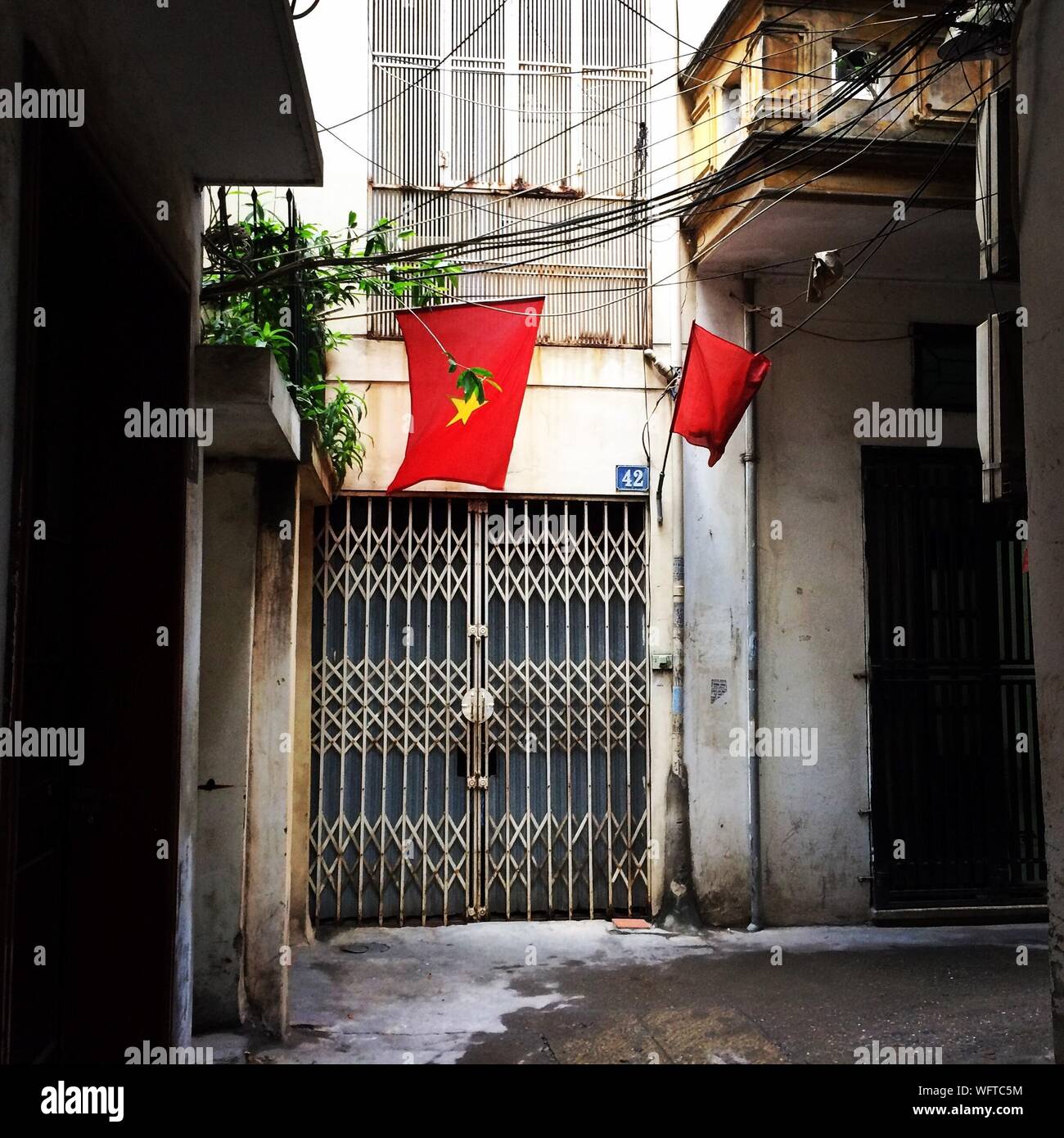 Red Flags Hanging Outside Building Stock Photo