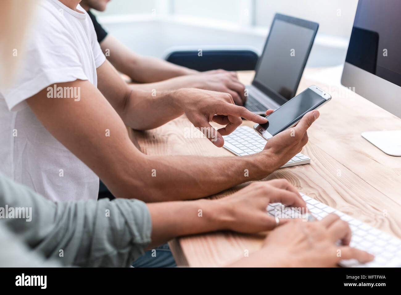 close up. a group of young people with devices sitting at the table