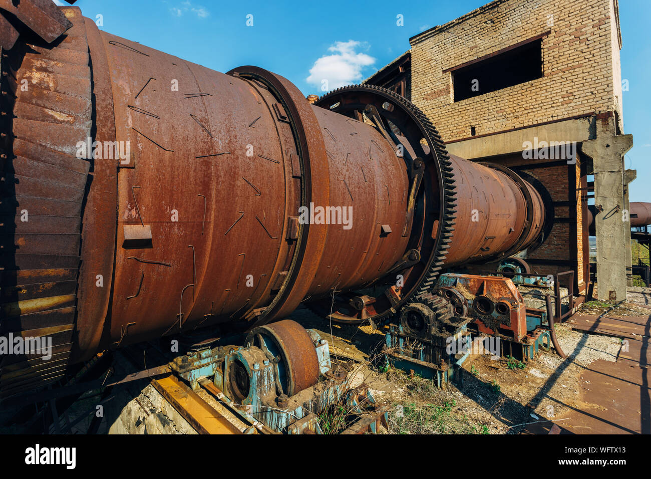 Old rusty rotating kiln in cement manufacturing plant. Stock Photo