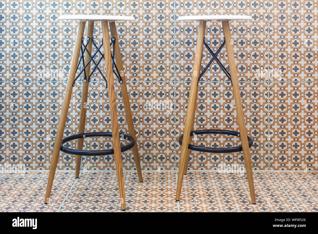 two bar stools stand against a wall in a cafe Stock Photo