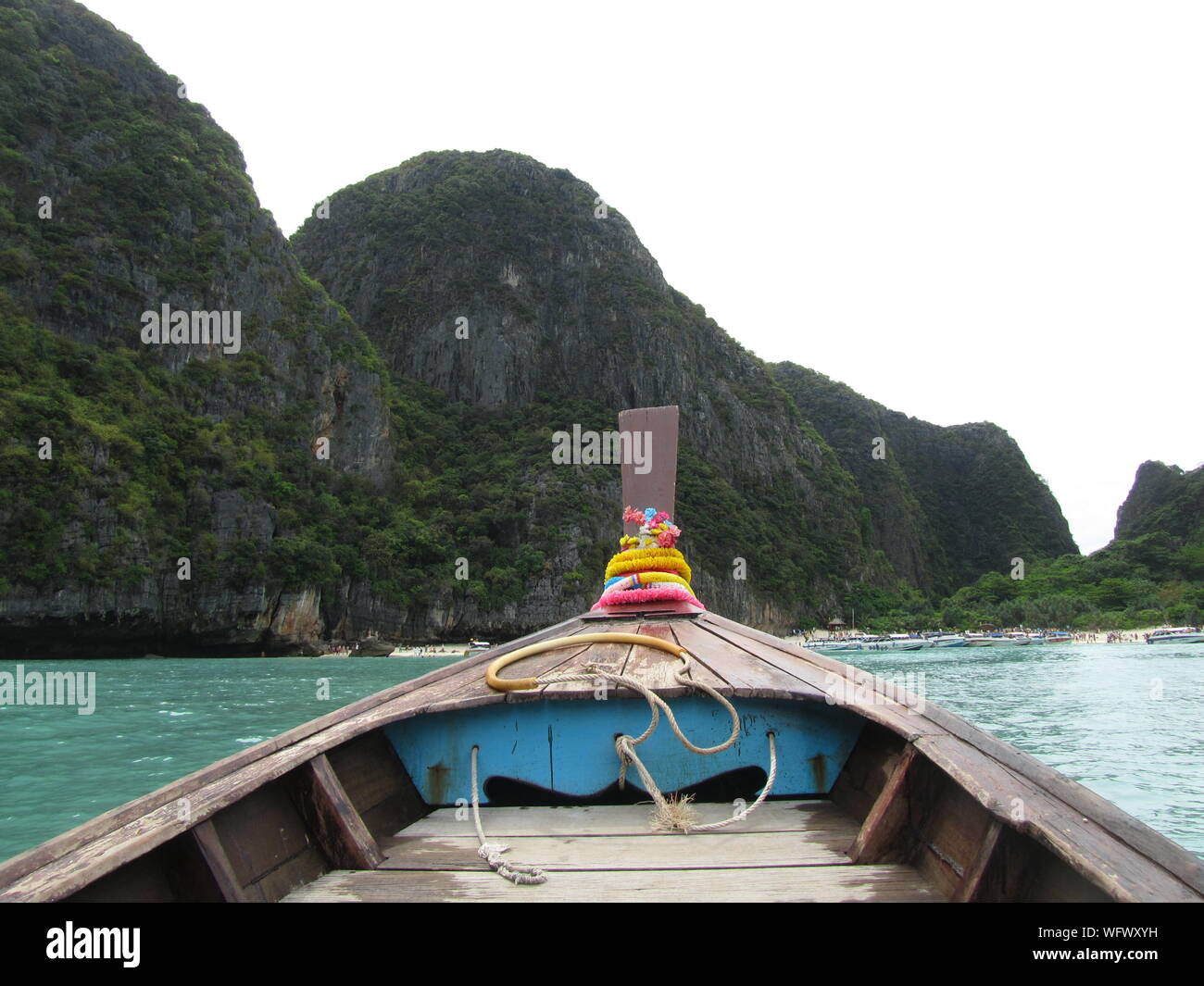 Longtail Boat In Sea Against Rocky Mountains At Krabi Province Stock Photo