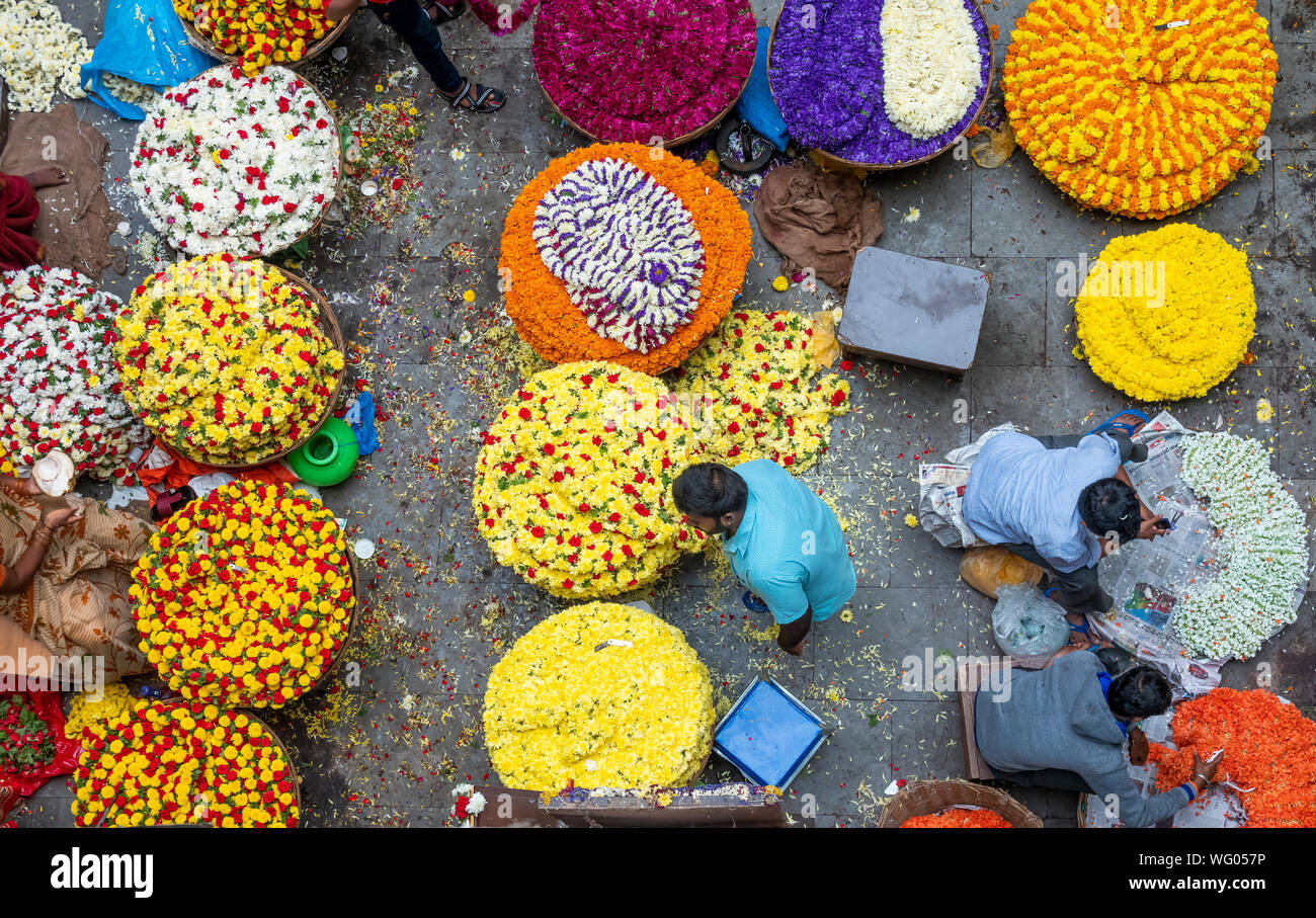 People selling Fresh flowers in wholesale inside KR flower market India which is one of the biggest flower markets in Asia Stock Photo