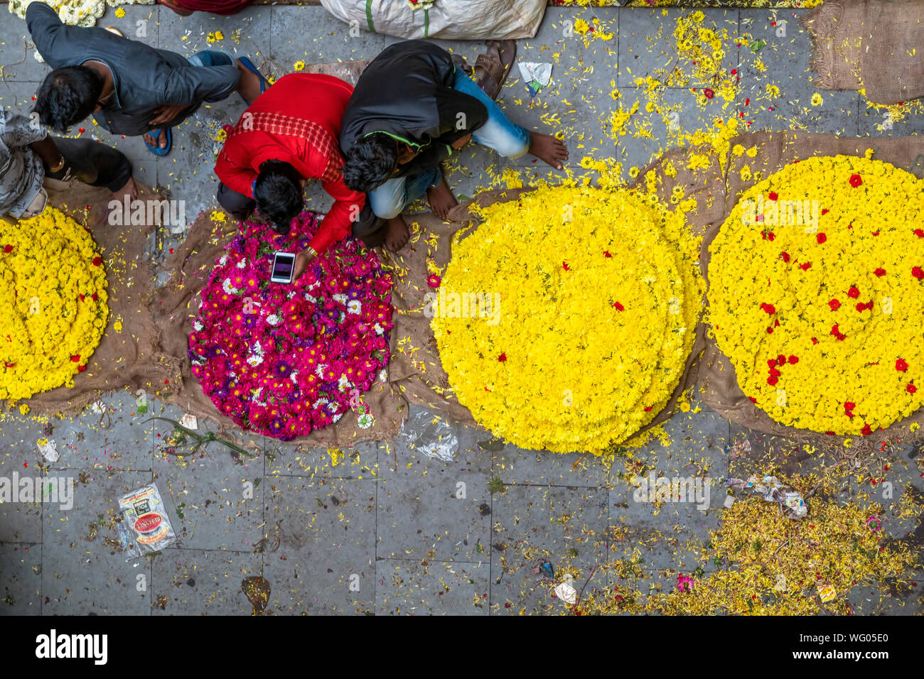 People selling Fresh flowers in wholesale inside KR flower market India which is one of the biggest flower markets in Asia Stock Photo