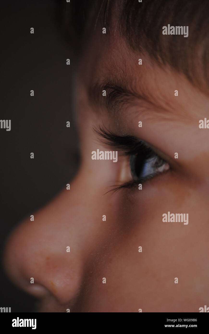 Close-up Of Boy Eye Against Black Background Stock Photo